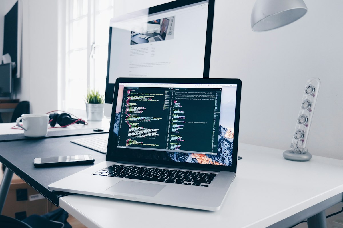 Modern laptop workstation displaying website development code, WordPress responsive layout, and technical optimization