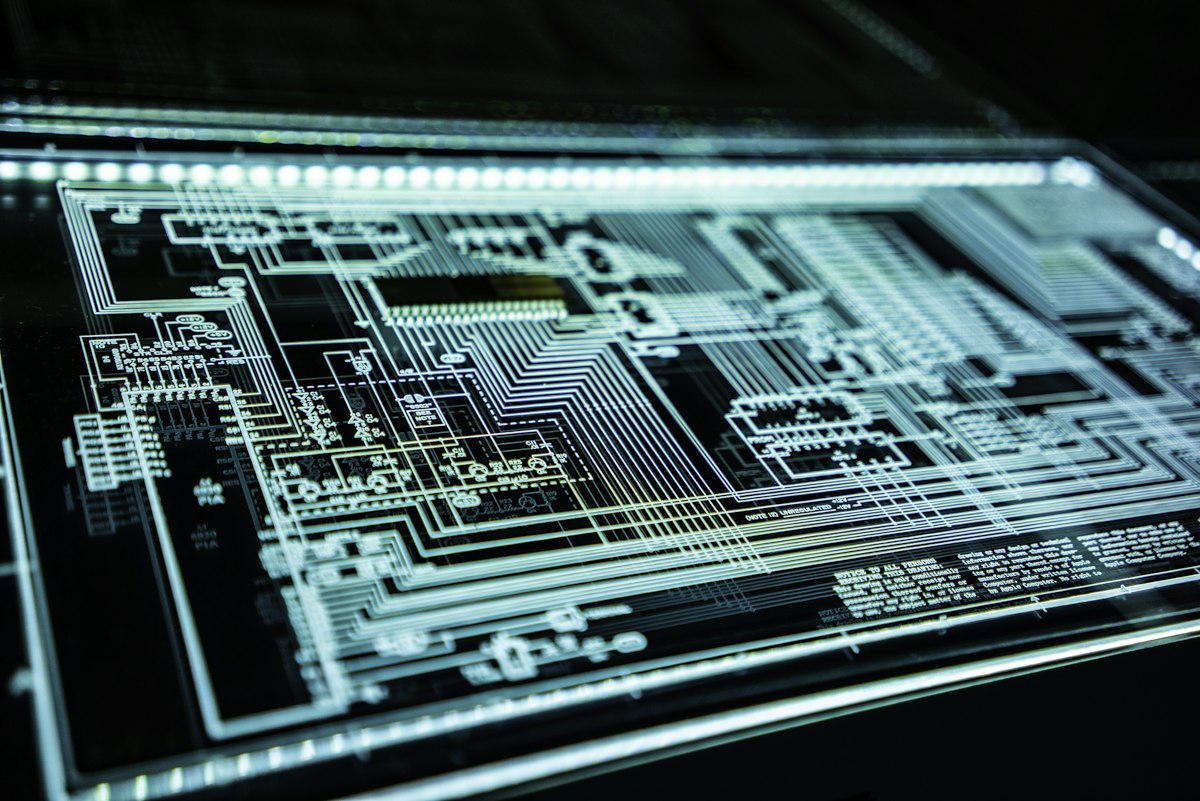 Cybersecurity specialist inspecting smartphone data protection protocols and network security warnings on laptop