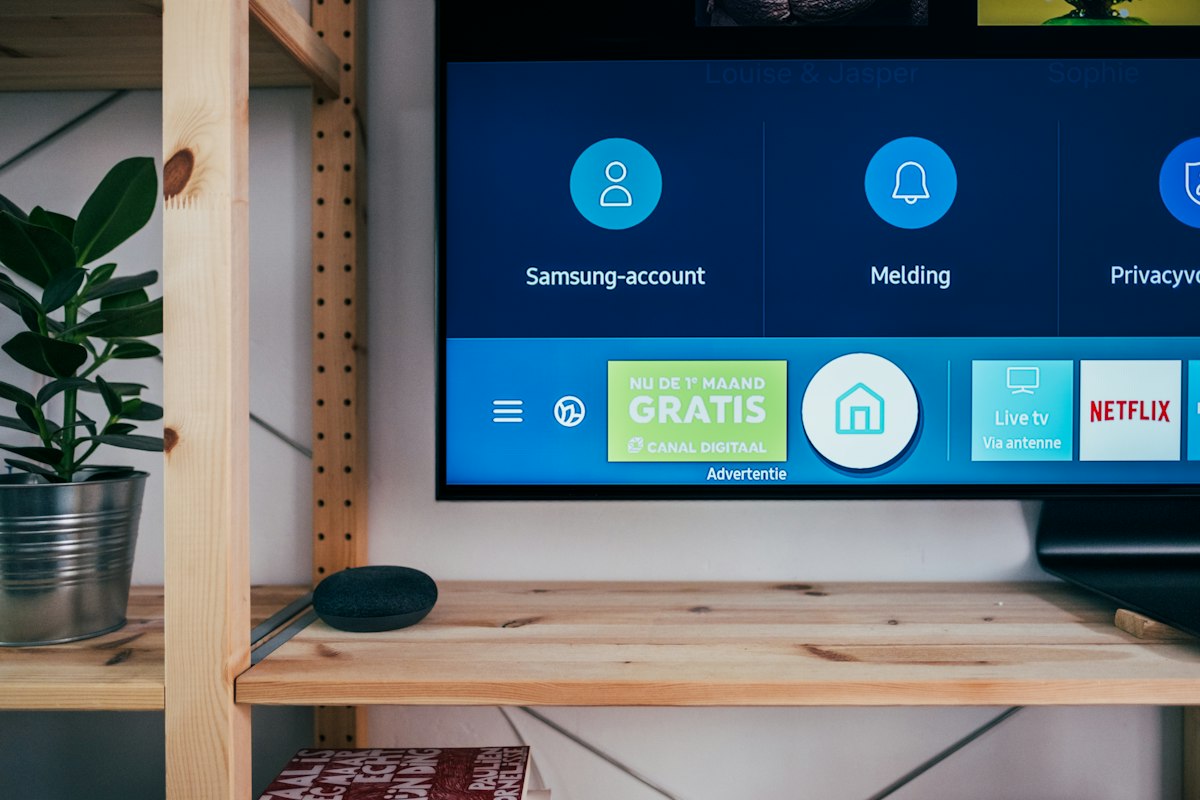 Smart TV in a modern living room displaying streaming application interface alongside mobile device for account activation