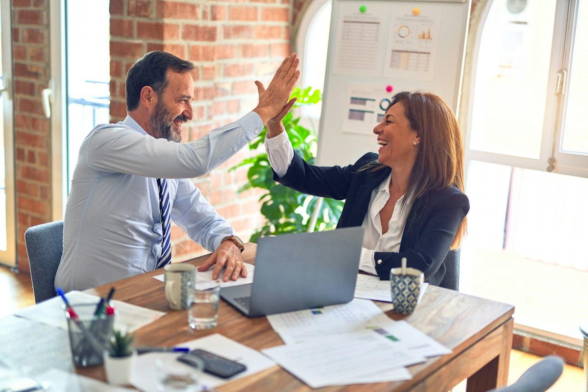 Digital marketing specialists collaborating at a modern office desk discussing online growth and SEO strategy