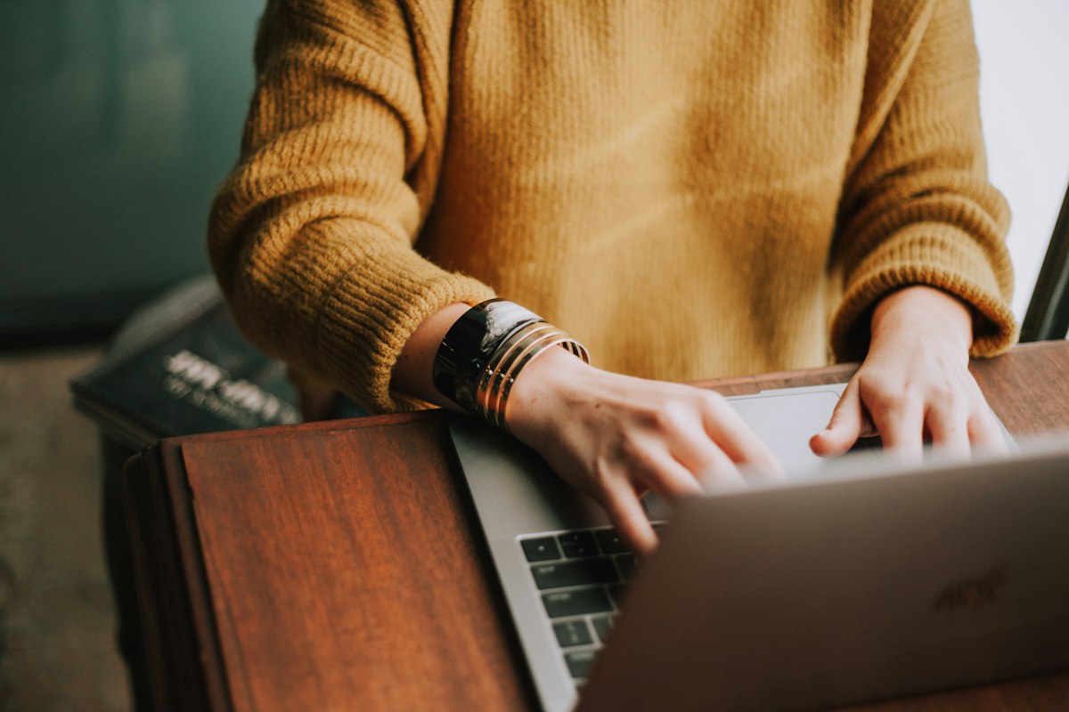 Marketing specialist researching search engine optimization keywords and drafting web content on a laptop