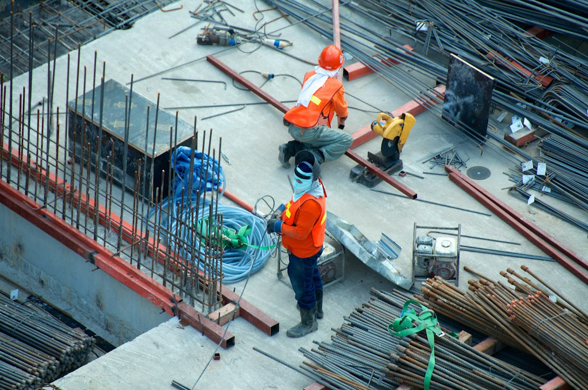 Telecommunications infrastructure and underground utility construction project showing civil engineering equipment and workers on site
