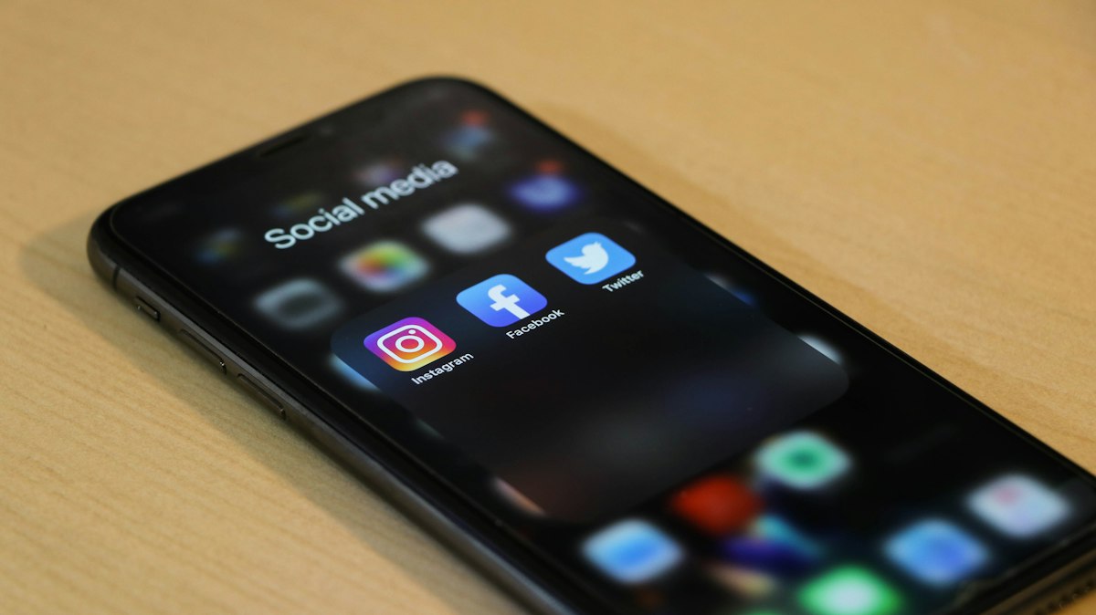 Smartphone displaying social media engagement feed with heart like notifications on a clean modern workspace desk