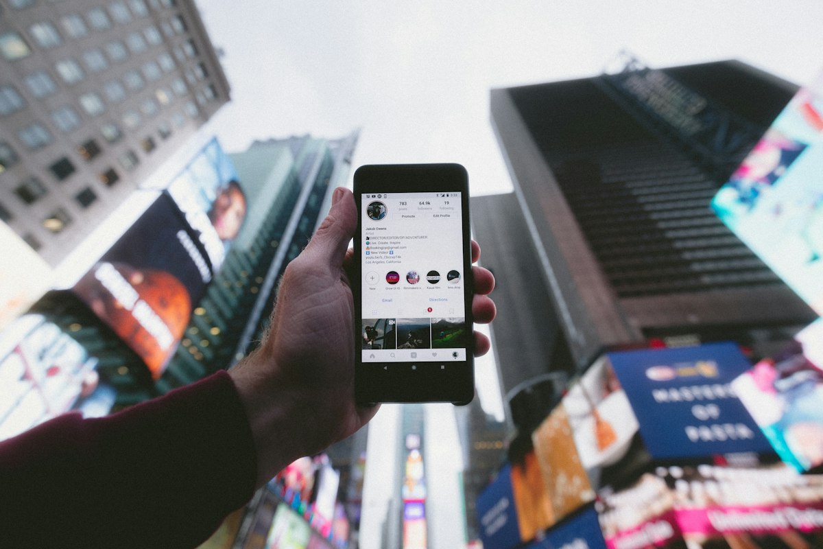 Content creator holding a smartphone creating and managing organic social media photo and video content